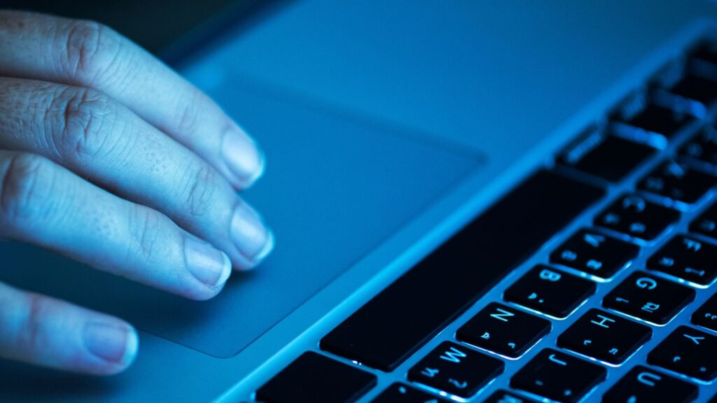 Protección de datos — mano sobre el trackpad de un notebook