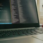inteligencia de ciberamenazas — notebook con código y celular sobre escritorio