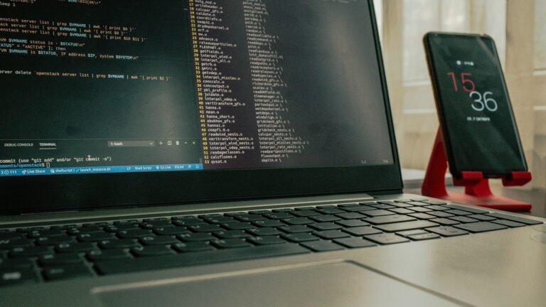 inteligencia de ciberamenazas — notebook con código y celular sobre escritorio