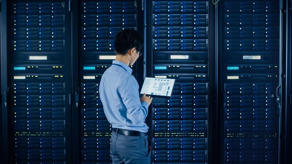 certificación Common Criteria — técnico revisa racks de almacenamiento con notebook