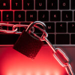 ransomware Payload — candado y cadenas sobre teclado con luz roja