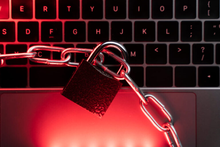 ransomware Payload — candado y cadenas sobre teclado con luz roja
