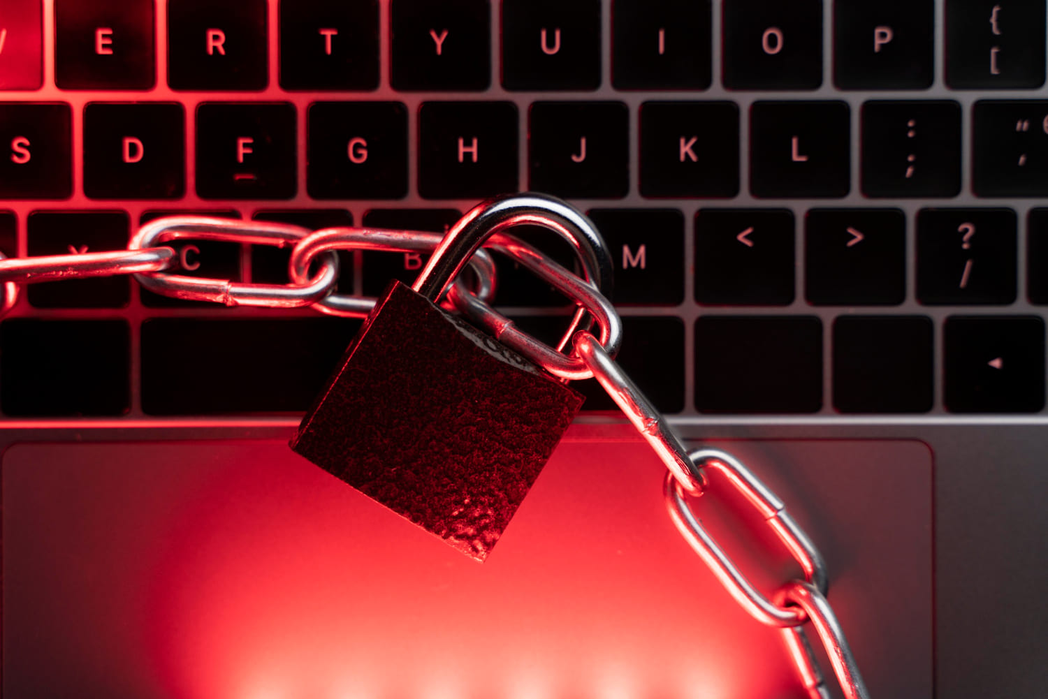 ransomware Payload — candado y cadenas sobre teclado con luz roja
